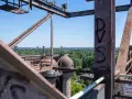 Industrielles Erbe in Duisburg: Rostige Stahlkonstruktionen und Kuppeln des Landschaftsparks Nord, mit Blick auf grüne Bäume und Gebäude.