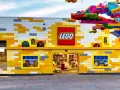 Bunte Lego-Steine schmücken das Gebäude und einen Baum. Ein lebendiger Lego-Freizeitpark lädt zum Spielen ein.