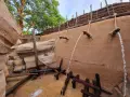 Wasserfälle speien auf einem Abenteuerpfad im Phantasialand. Holz und Felsen schaffen eine rustikale Atmosphäre.