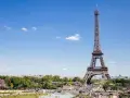 Eiffelturm in Paris, mit Menschen im Park. Hier gibt es viele Paris Tipps und Tricks für Ihren Besuch.