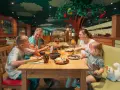 Familie genießt ein fröhliches Frühstück in einem fantasievollen Legoland Restaurant mit Baumdeko.