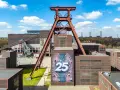 Große Fördergerüst-Struktur auf dem Gelände der Zeche Zollverein, die eine Ausstellung mit der Zahl 25 feiert.