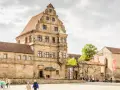 Historische Gebäude im Herzen der Bamberger Innenstadt, mit Menschen, die den Platz erkunden.