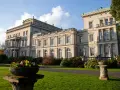 Prachtvolle Krupp Villa mit gepflegtem Garten und Blumenkübeln im Sonnenschein.