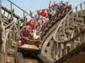 Menschen jubeln auf der Holzachterbahn "Wodan" im Europa-Park. Die rasante Fahrt sorgt für pure Freude und Adrenalin.