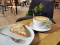 Ein Stück Kuchen mit Nüssen und eine Latte Art im **Kuchen Cafe**.