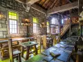 Rustikale Phantasialand Taverne mit Steinwänden, Holztischen und Bänken, Kerzenlicht und mittelalterlichem Flair.