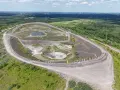 Die Halde Haniel mit ihrem Amphitheater und bunten Stelen, umgeben von grüner Natur und Windrädern in der Ferne.