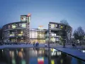 Abendstimmung am Centro Oberhausen. Die beleuchtete Fassade mit den Logos von McDonald's und Coca-Cola spiegelt sich im Wasser.