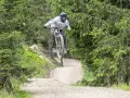 Mountainbiker springt über eine Schanze im Wald. Die **Halde Hoppenbruch** bietet eine tolle Kulisse für diesen Sprung.