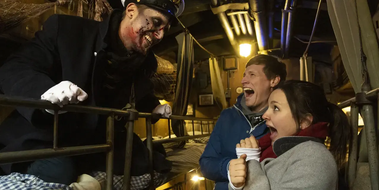Gruselige Begegnung auf der Bavaria Filmstadt Spooky Tour. Ein Schauspieler mit blutigem Gesicht erschreckt ein Paar.