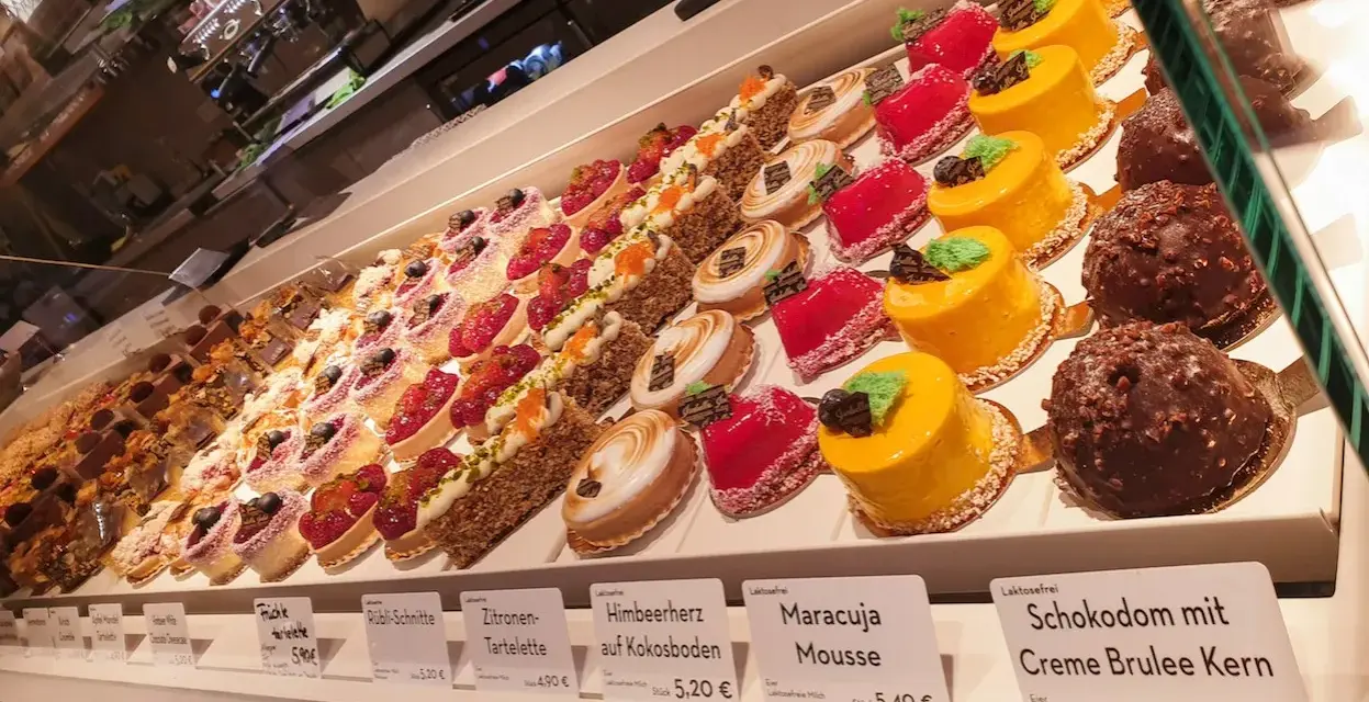 Isabella glutenfreie Pâtisserie: Vielfalt an bunten, kleinen Törtchen und Kuchen, darunter Frucht- und Schokoladenkreationen.