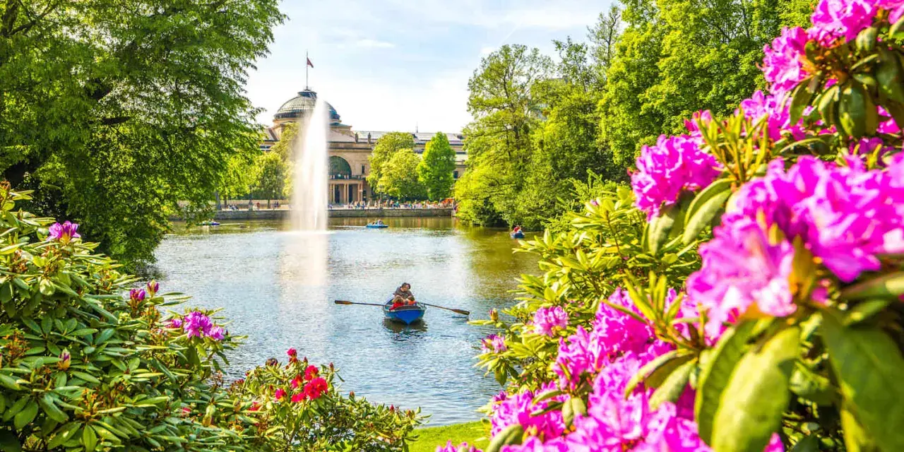 Bootsfahrt auf dem See mit Brunnen im Hintergrund – eine schöne Idee für Wiesbaden Unternehmungen.