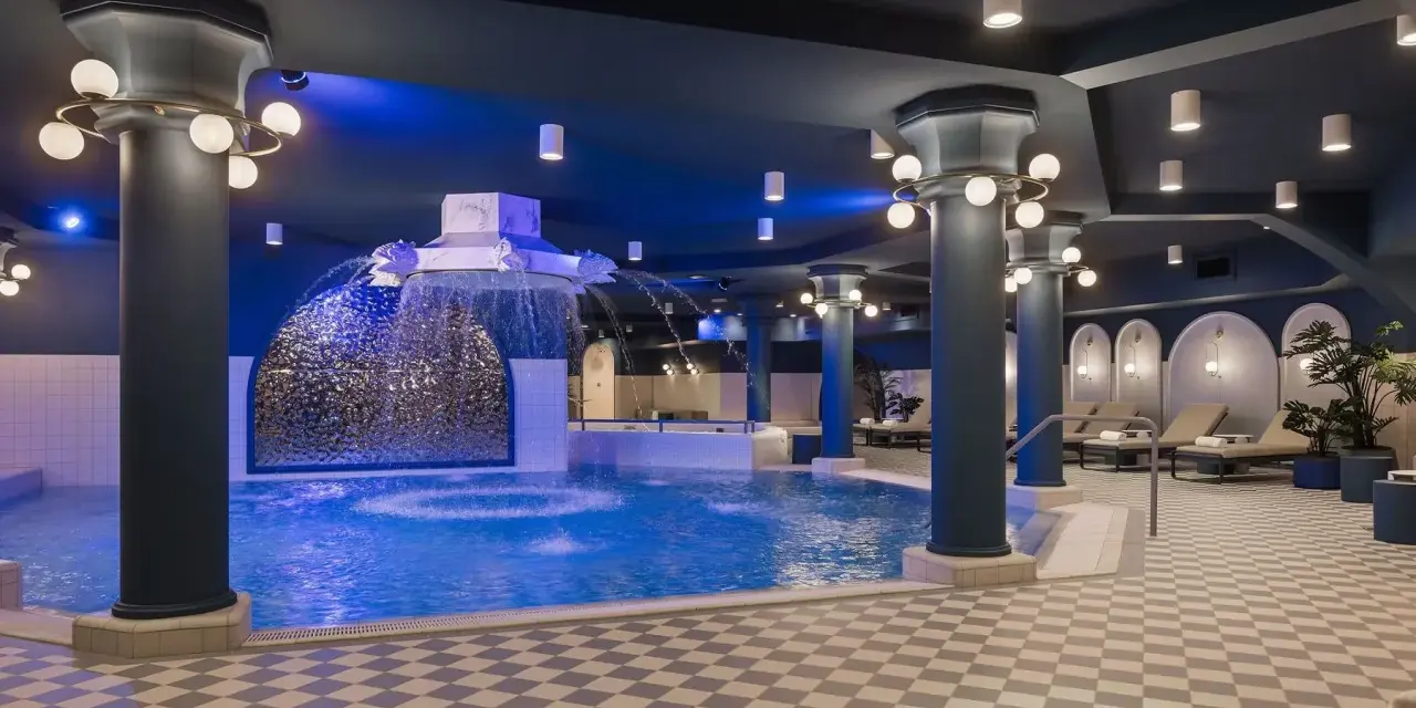 Ein luxuriöses Schwimmbad im Efteling-Stil mit Wasserspielen und Entspannungsbereichen.