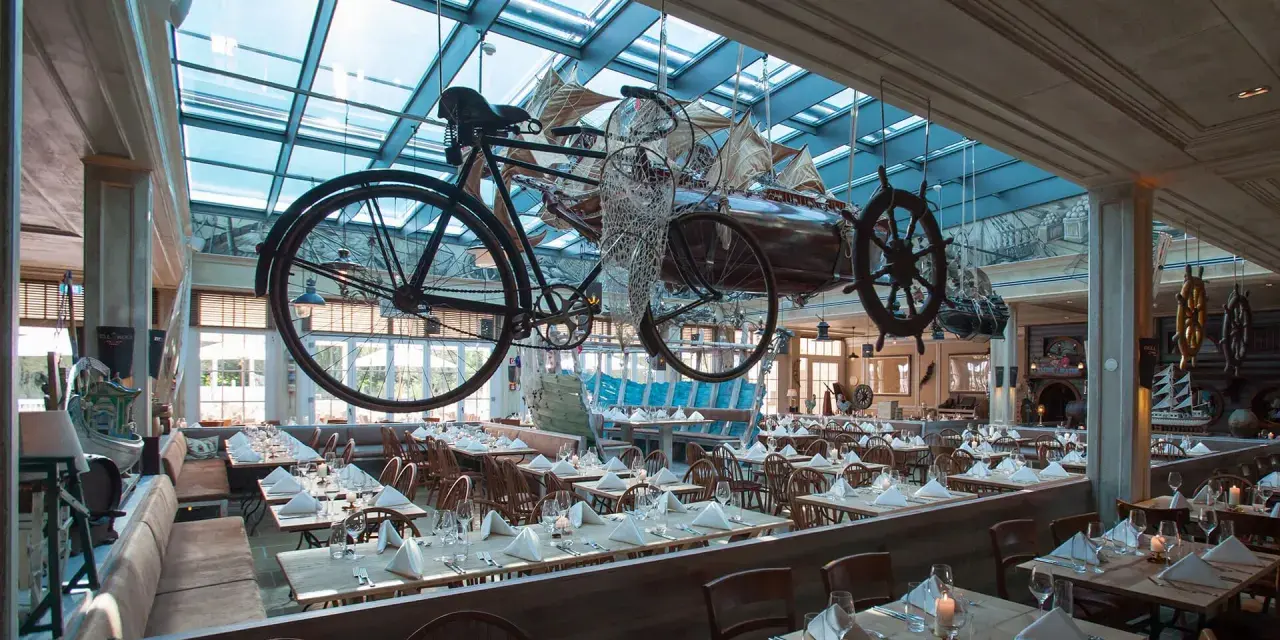 Einzigartiges Ambiente im Bell Rock Restaurant. Die Speisekarte wartet in einem Raum mit Deckeninstallationen, die an Schiffe und Fahrräder erinnern.