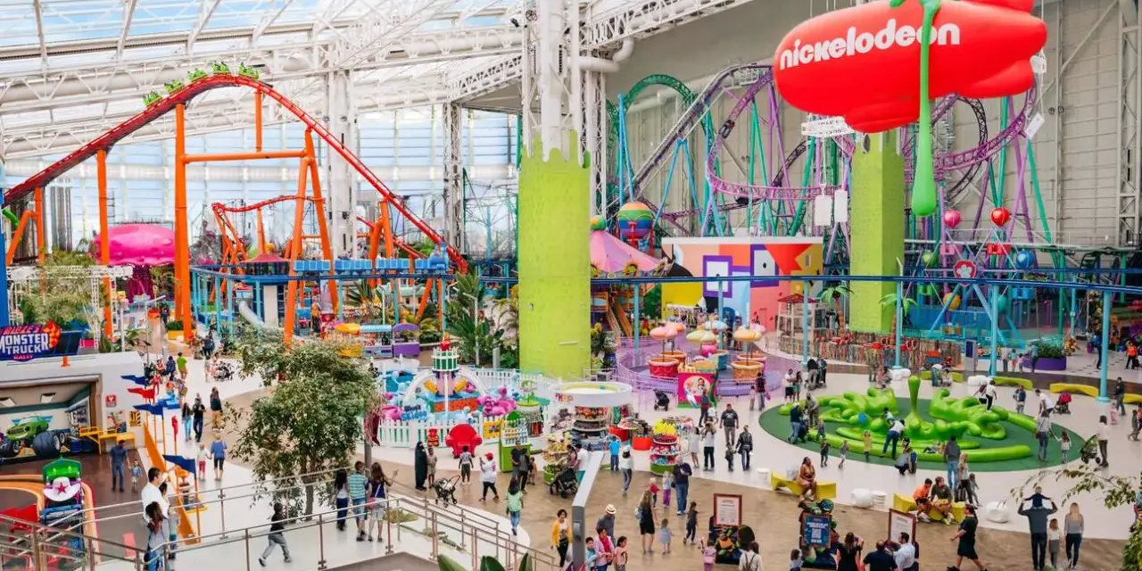 Buntes Treiben im Nickelodeon Park Deutschland mit Achterbahnen, Fahrgeschäften und vielen Besuchern.