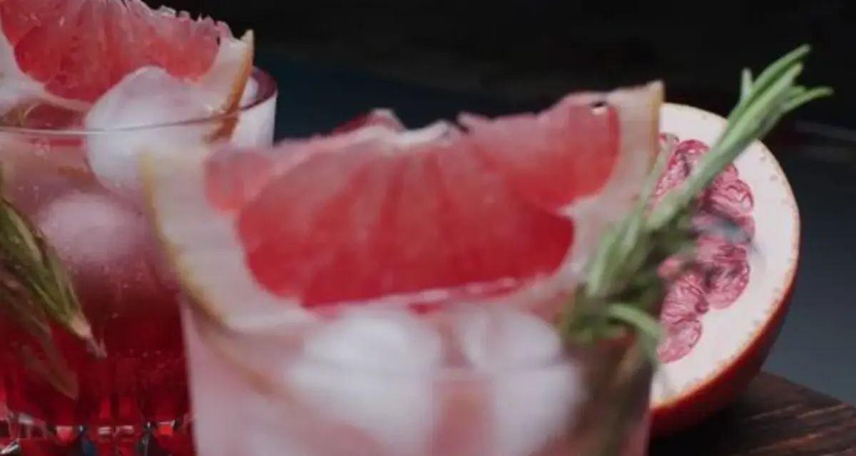 Erfrischende sommer drinks mit tonic water, Eiswürfeln und Grapefruit-Garnitur. Ein Hauch Rosmarin rundet das Bild ab.