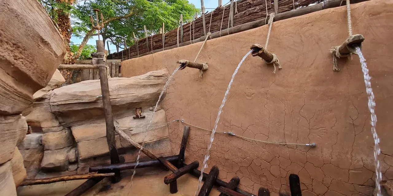 Wasserfälle speien auf einem Abenteuerpfad im Phantasialand. Holz und Felsen schaffen eine rustikale Atmosphäre.