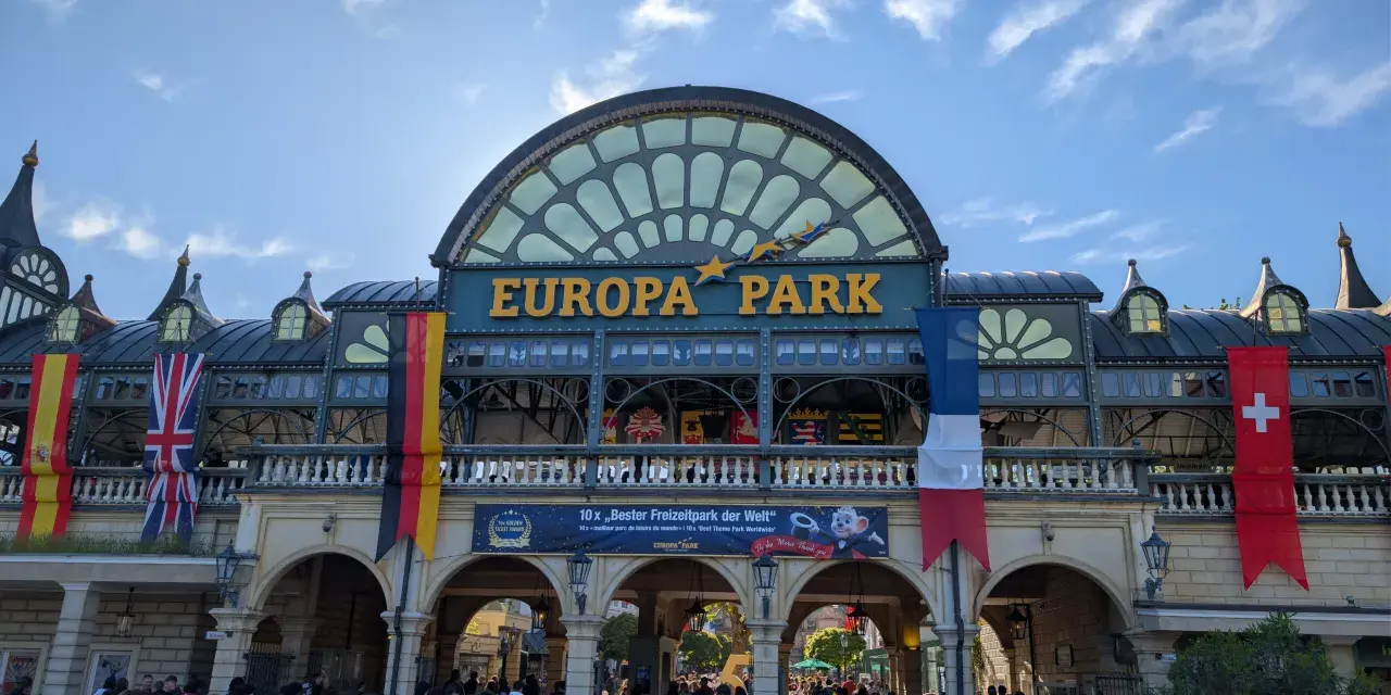 Einlass zum Europa-Park mit Fahnen und jubelnden Besuchern.