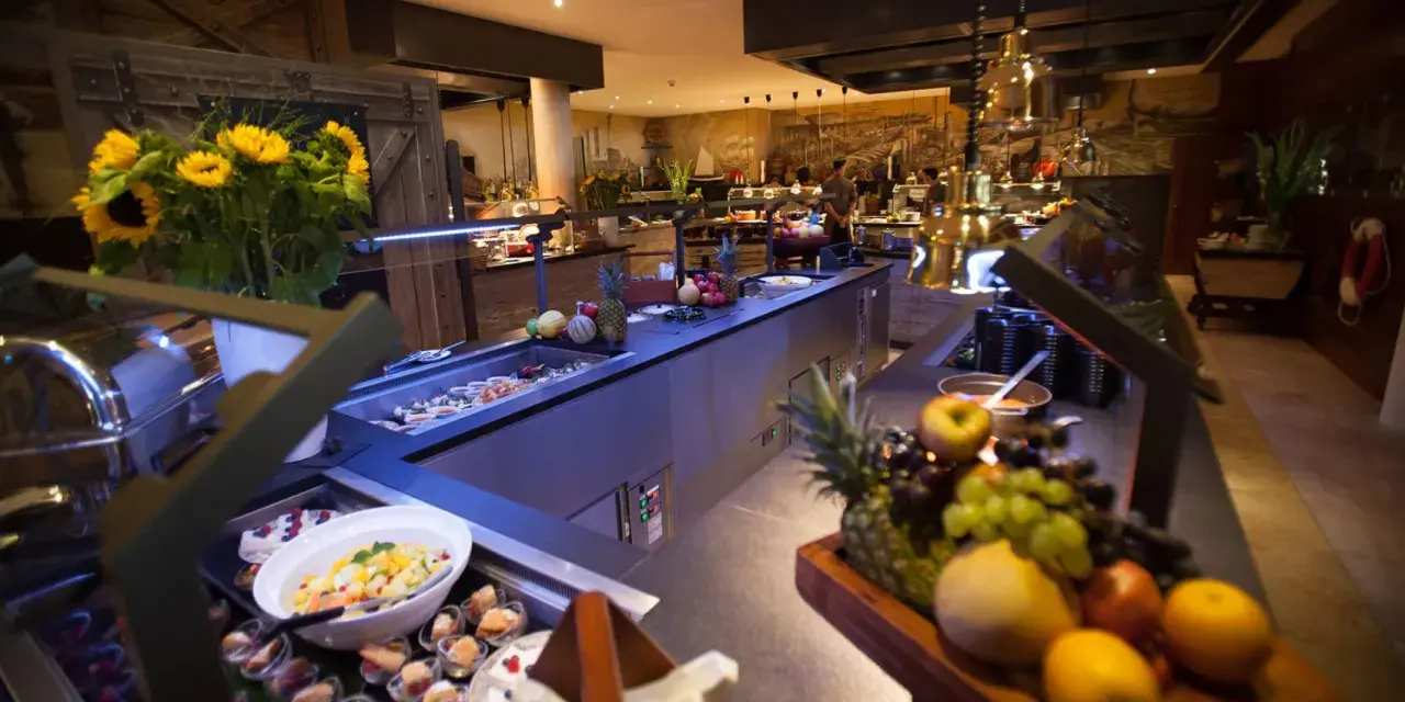 Ein üppiger Bell Rock Buffet-Tisch mit frischem Obst, Salaten und Desserts, dekoriert mit Sonnenblumen.