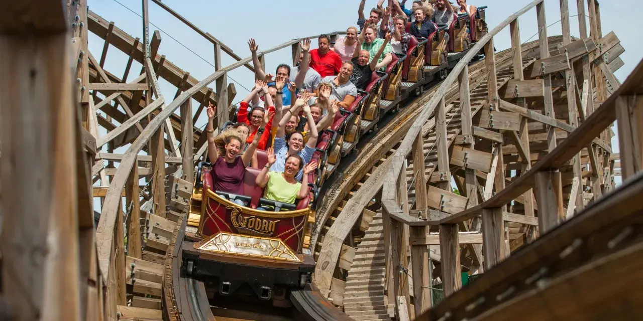 Menschen jubeln auf der Holzachterbahn "Wodan" im Europa-Park. Die rasante Fahrt sorgt für pure Freude und Adrenalin.
