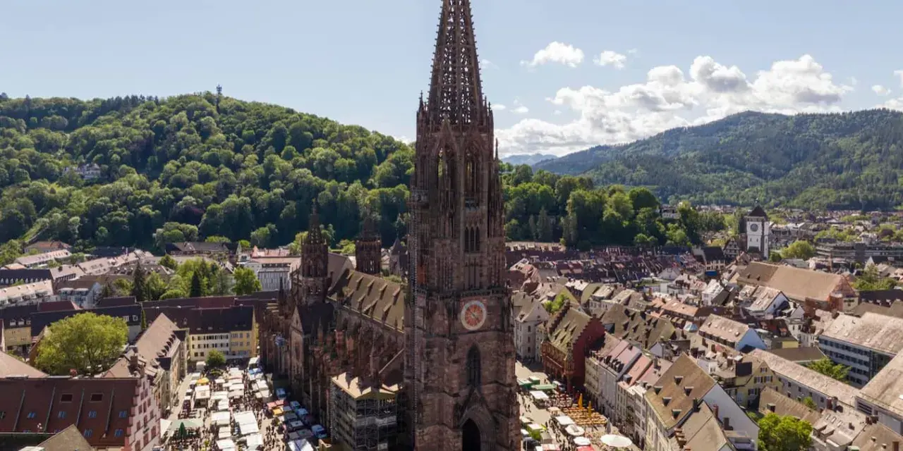 Blick auf den Freiburger Münsterplatz mit Marktständen. Hier kann man in Freiburg viel entdecken, von der beeindruckenden Architektur bis zum lebhaften Treiben.