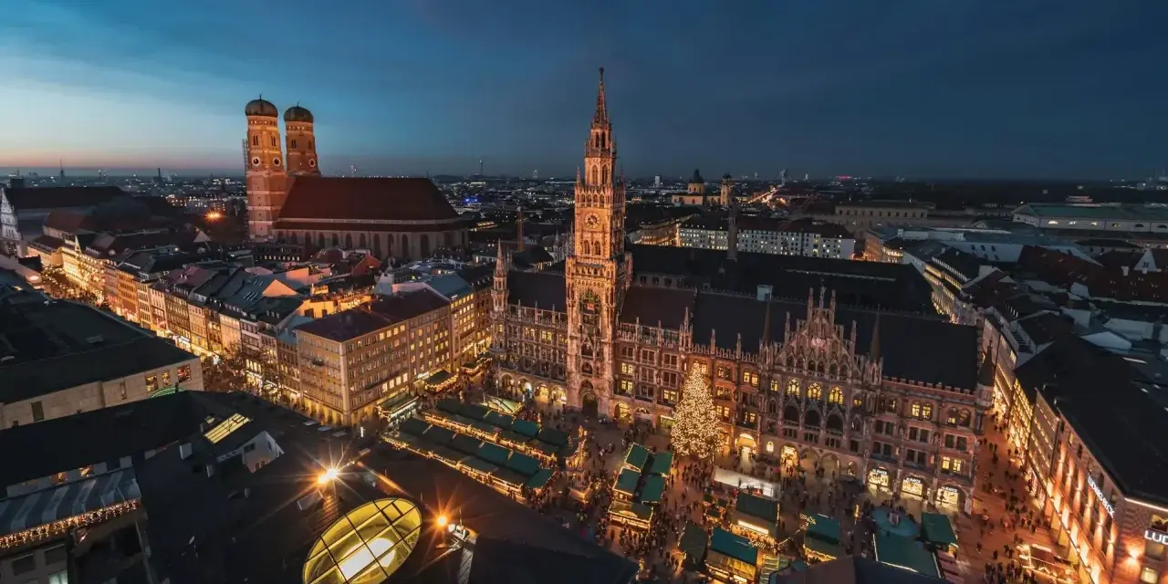 Beleuchtetes Rathaus und Christkindlmarkt in München, ein perfekter Ort für Munich Sightseeing bei Nacht.