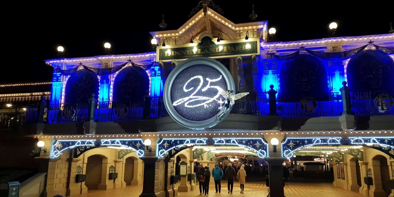 Disneyland Paris im Winter, festlich beleuchtet mit der Zahl 25 und einer Fee.