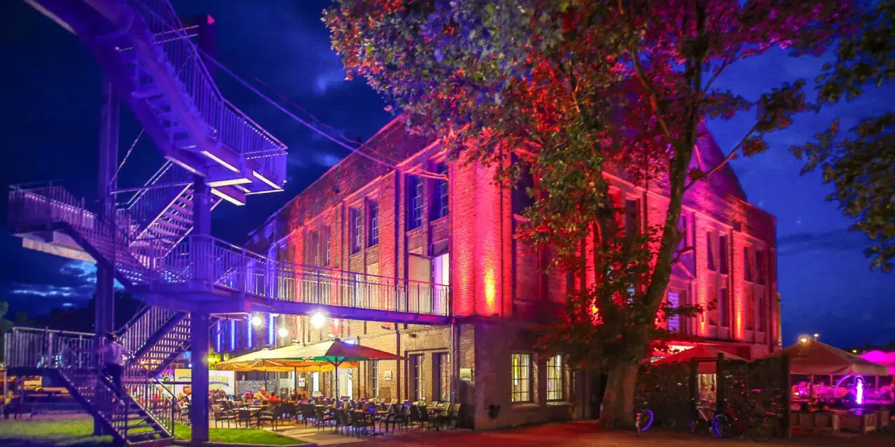 Abendstimmung mit bunten Lichtern und einer Treppe, die zum "Extraschicht Dorsten" führt.
