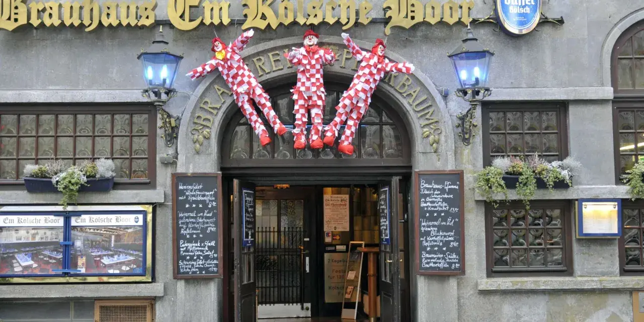 Drei Clowns hängen vor dem Brauhaus Em Kölsche Boor. Wann wird der Nubbel verbrannt? Bald, wenn die Karnevalszeit beginnt!