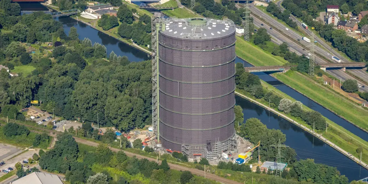 Gasometer Oberhausen aus der Vogelperspektive mit Kanal, Autobahn und Grünflächen.