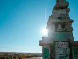 Sonnenstrahlen brechen durch eine Betonkonstruktion auf der Halde Rheinelbe, die mit Graffiti übersät ist.