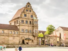 Historische Gebäude im Herzen der Bamberger Innenstadt, mit Menschen, die den Platz erkunden.