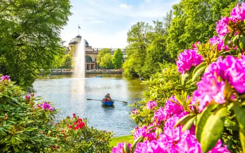Bootsfahrt auf dem See mit Brunnen im Hintergrund – eine schöne Idee für Wiesbaden Unternehmungen.