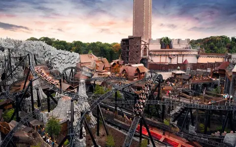 Achtung, **Phantasialand Geburtstagskinder**! Die Achterbahn rast durch eine mittelalterliche Kulisse mit Burg und Felsen.