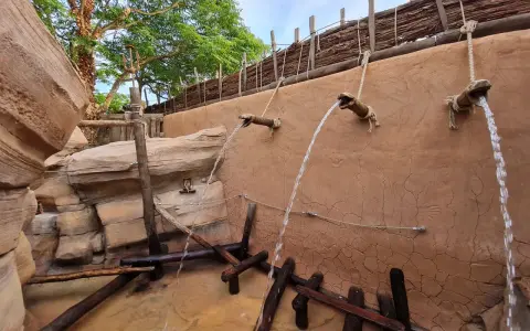 Wasserfälle speien auf einem Abenteuerpfad im Phantasialand. Holz und Felsen schaffen eine rustikale Atmosphäre.
