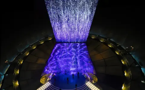 Im Gasometer Oberhausen erstrahlt eine Projektion aus tausenden Lichtpunkten, die wie ein Sternenhimmel oder ein Wasserfall wirken.