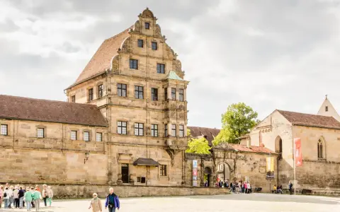 Historische Gebäude im Herzen der Bamberger Innenstadt, mit Menschen, die den Platz erkunden.