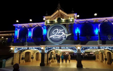 Disneyland Paris im Winter, festlich beleuchtet mit der Zahl 25 und einer Fee.