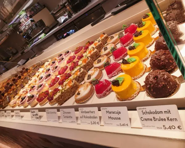Isabella glutenfreie Pâtisserie: Vielfalt an bunten, kleinen Törtchen und Kuchen, darunter Frucht- und Schokoladenkreationen.
