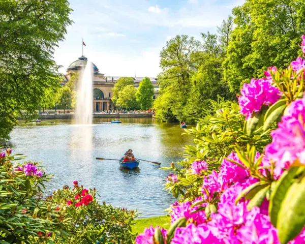 Bootsfahrt auf dem See mit Brunnen im Hintergrund – eine schöne Idee für Wiesbaden Unternehmungen.