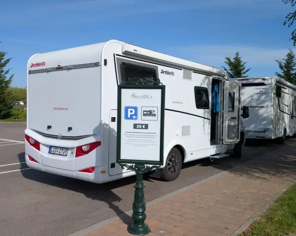 Wohnmobile parken am Europapark. Ein Schild weist auf die Parkgebühr von 20 € für Rulantica hin.