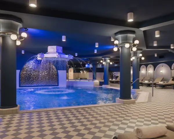 Ein luxuriöses Schwimmbad im Efteling-Stil mit Wasserspielen und Entspannungsbereichen.
