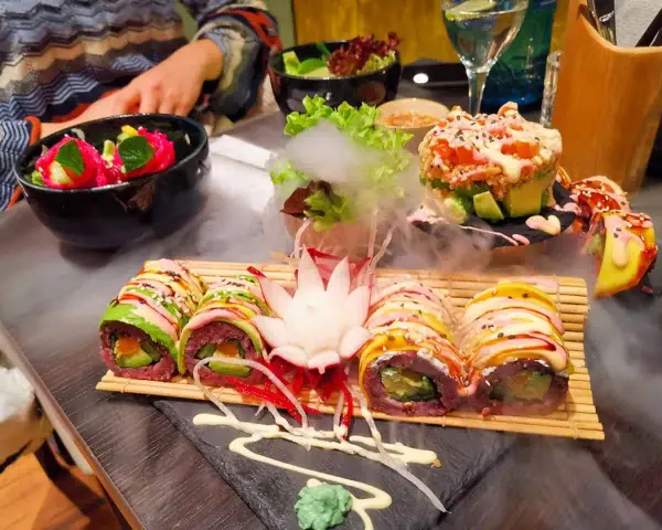 Köstliches vegetarisches Sushi mit Avocado und bunten Gemüsesorten, serviert mit Rauch-Effekt. Ein Genuss für Augen und Gaumen in diesem **restaurant vegetarisch**.