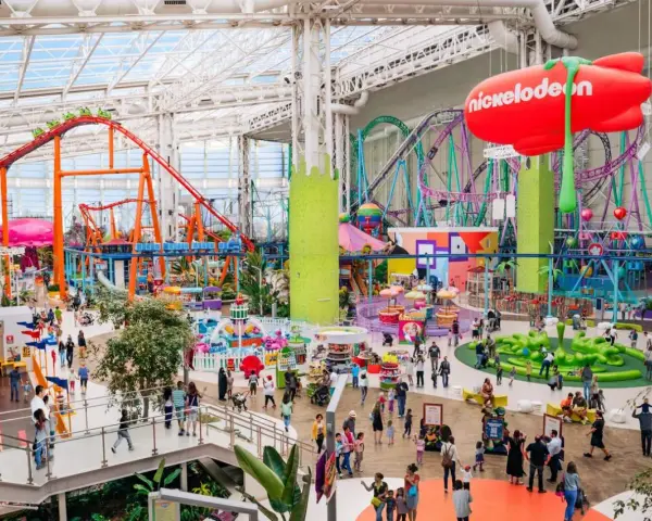 Buntes Treiben im Nickelodeon Park Deutschland mit Achterbahnen, Fahrgeschäften und vielen Besuchern.