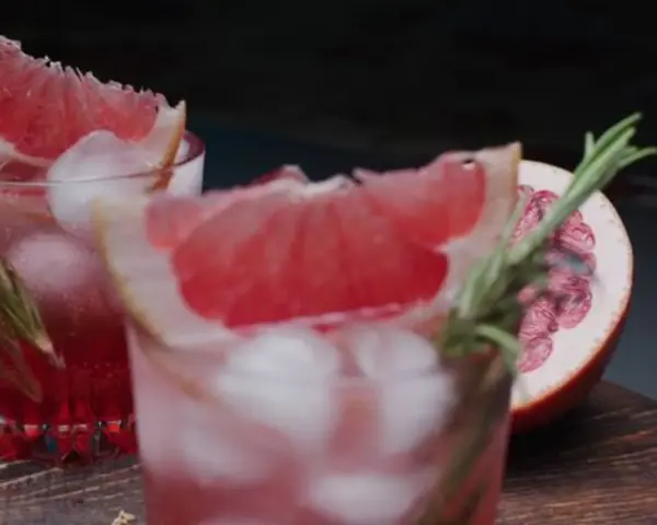 Erfrischende sommer drinks mit tonic water, Eiswürfeln und Grapefruit-Garnitur. Ein Hauch Rosmarin rundet das Bild ab.