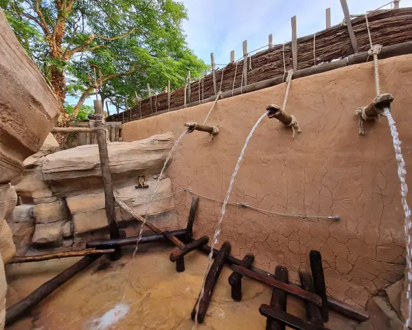 Wasserfälle speien auf einem Abenteuerpfad im Phantasialand. Holz und Felsen schaffen eine rustikale Atmosphäre.