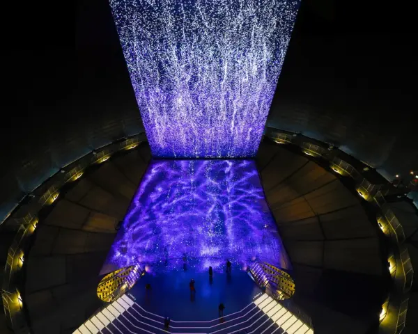 Im Gasometer Oberhausen erstrahlt eine Projektion aus tausenden Lichtpunkten, die wie ein Sternenhimmel oder ein Wasserfall wirken.