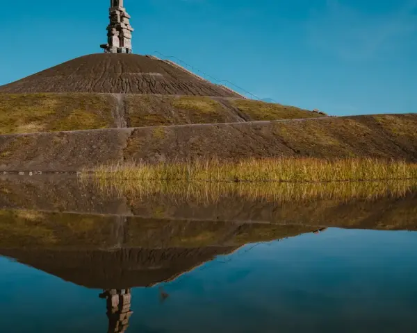 Die Himmelstreppe Gelsenkirchen spiegelt sich im Wasser. Ein Kunstwerk auf einer Halde.