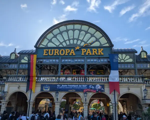 Einlass zum Europa-Park mit Fahnen und jubelnden Besuchern.